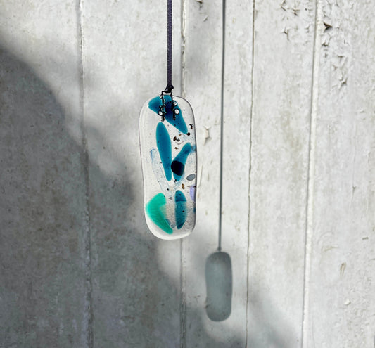 Abstract pendant with blue and green design on a white background