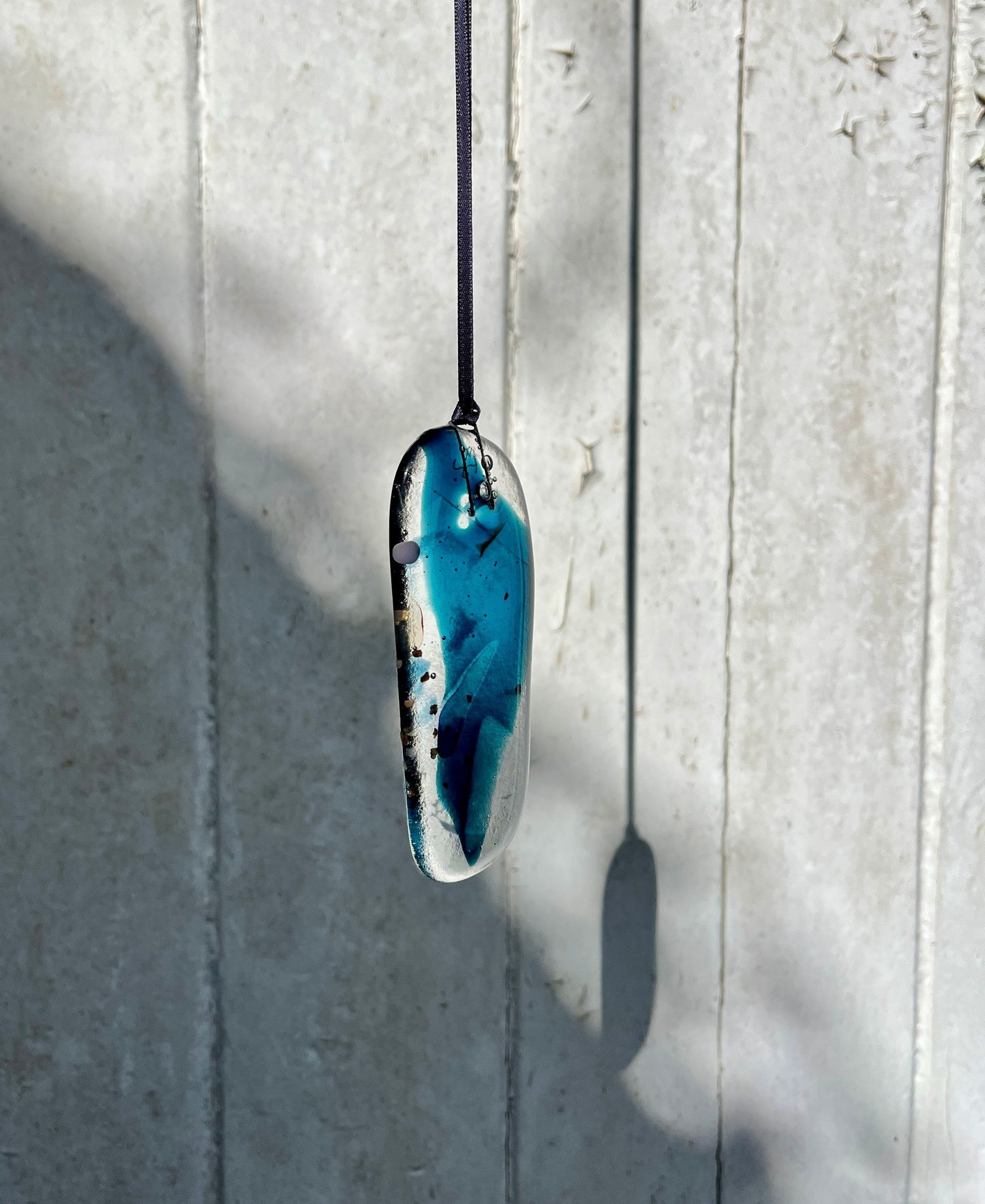 Blue pendant necklace on a light gray background