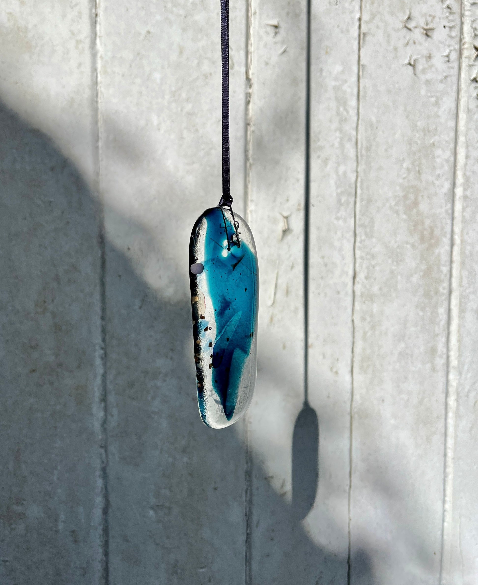 Blue pendant necklace on a light gray background