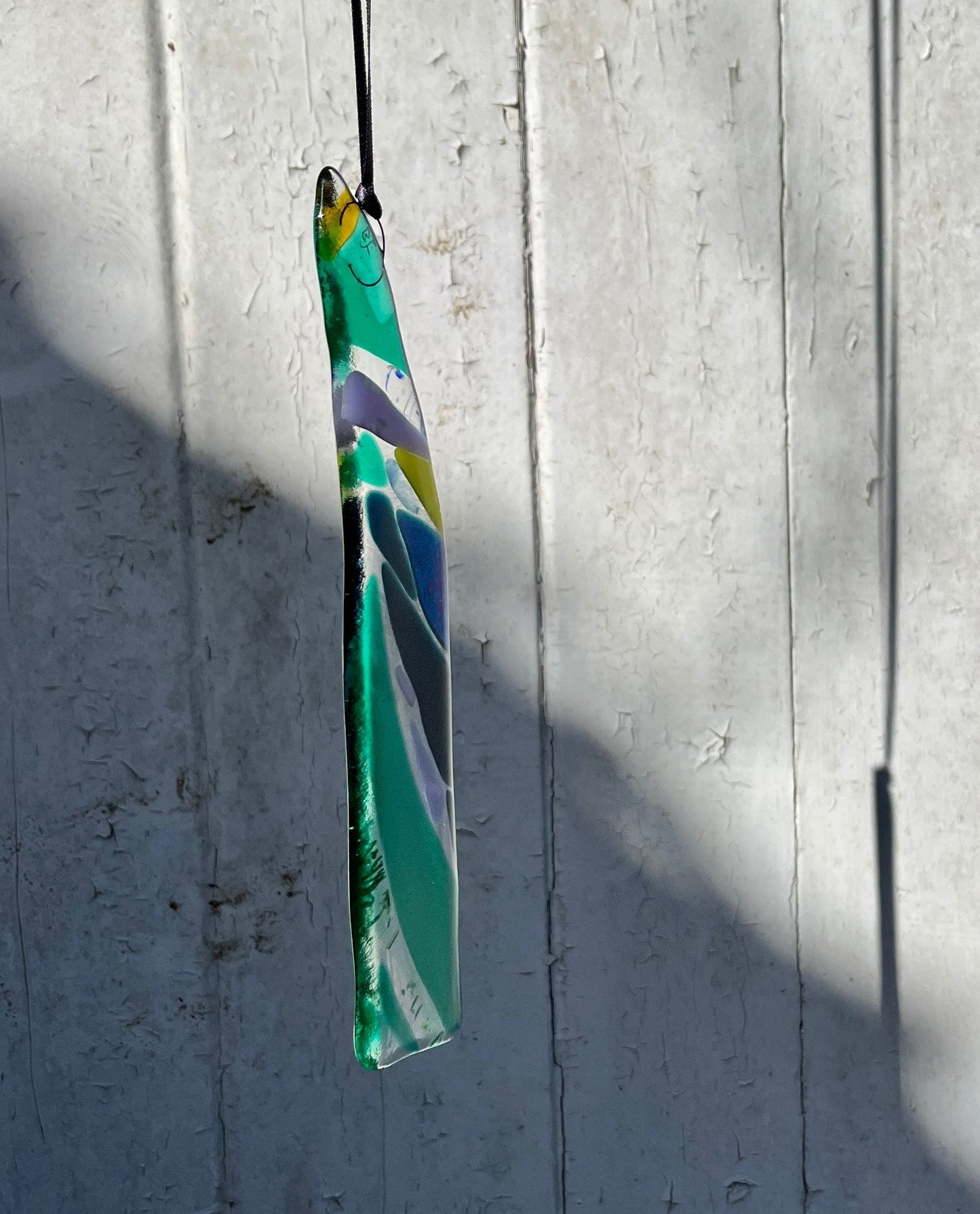 Kilned glass pendant made in greens and blues