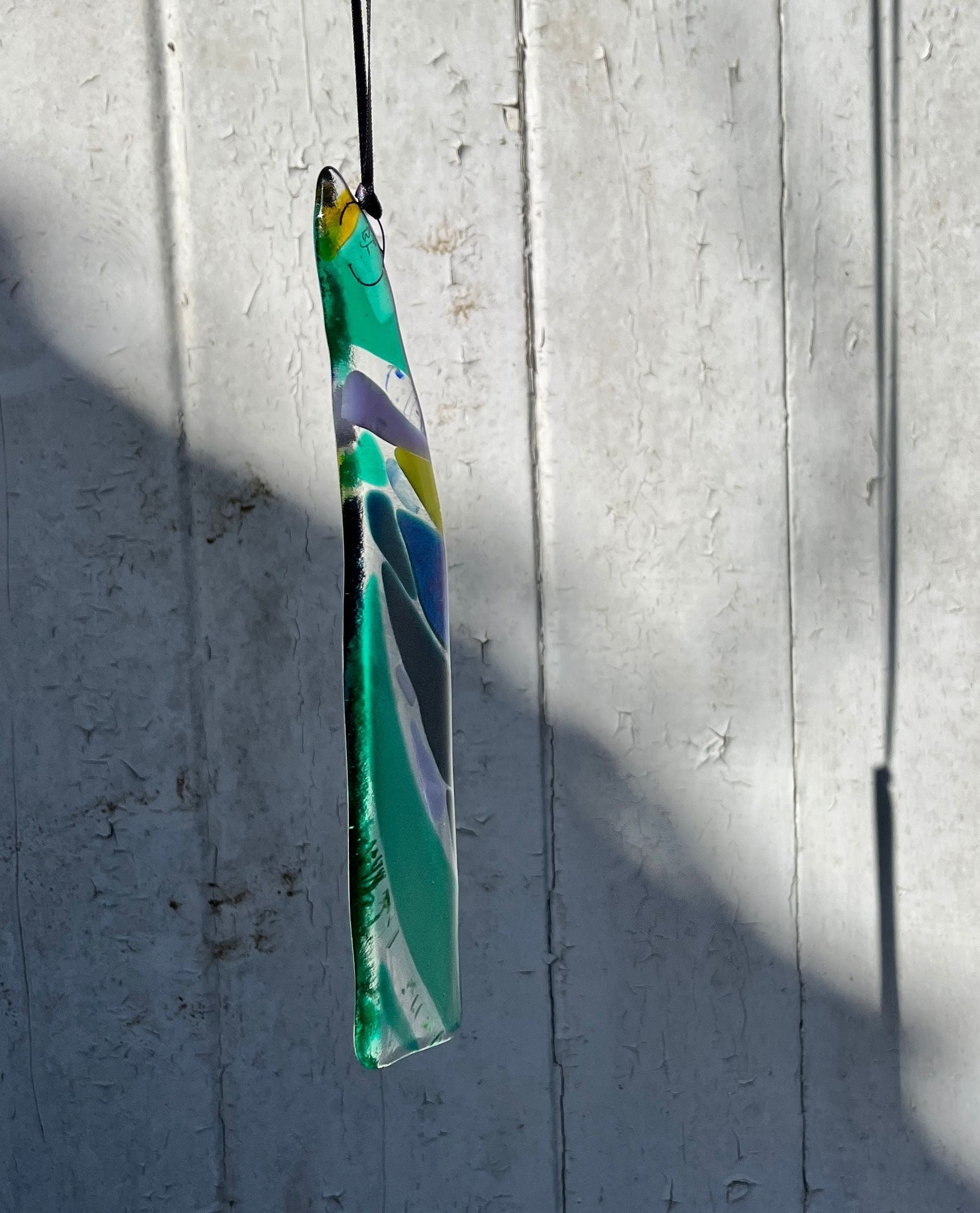 Kilned glass pendant made in greens and blues