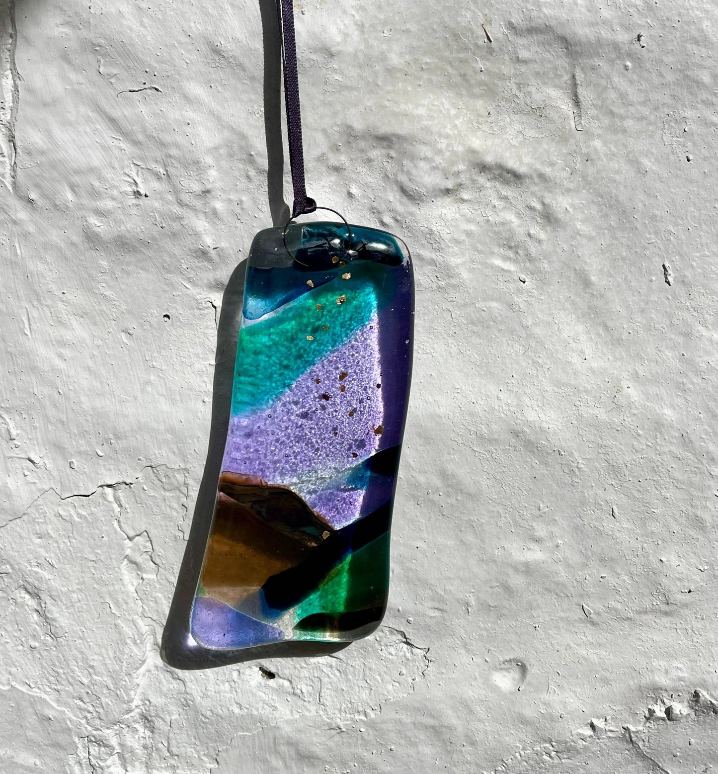 Multicolored pendant on a textured gray surface